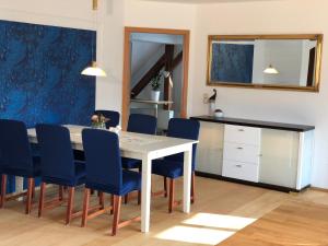 ein Esszimmer mit einem Tisch und blauen Stühlen in der Unterkunft Leipziger Logis in Leipzig + 27 Fotos