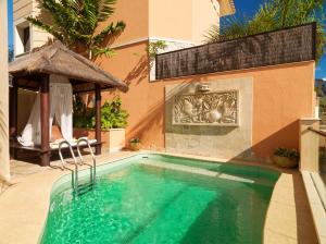 a swimming pool with a gazebo next to a house at Royal Garden Villas, Luxury Hotel in Adeje