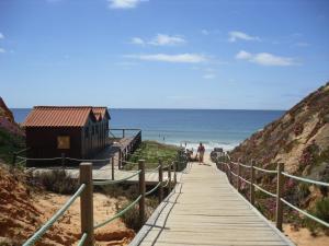 un paseo marítimo hasta la playa con un edificio en él en Alfamar V3 Falésia Beach, en Albufeira