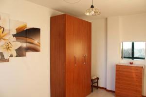 Cette chambre comprend une armoire en bois et une commode. dans l'établissement Oasi del piacere, à Pise