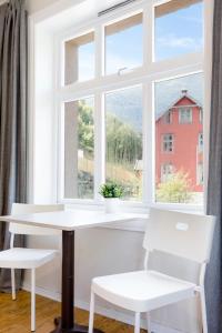 un tavolo bianco e due sedie davanti a una finestra di Slottet Apartments a Tyssedal