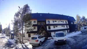 dos autos estacionados en un estacionamiento frente a un edificio en Résidence Le Parc en Font Romeu Odeillo Via