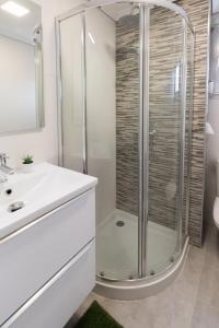 a white bathroom with a shower and a sink at Apartamento Avenida de Colón con Aire Acondicionado in Logroño