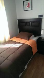 1 dormitorio con 1 cama grande y cabecero negro en Hotel con C en Concepción