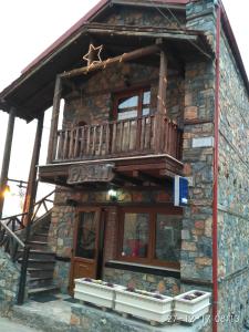 a log cabin with a balcony on top of it at Rachati Kaimaktsalan in Palaios Agios Athanasios