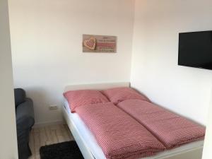 ブラウンラーゲにあるApartment HarzZwergの赤いシーツが敷かれたベッドが備わる客室です。