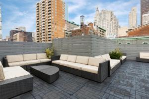 a patio with couches and tables on a city rooftop at Lex Hotel NYC in New York