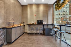 a bar with stools in a room with a window at Lex Hotel NYC in New York