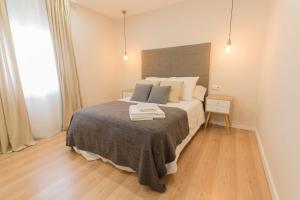 a bedroom with a bed with a gray blanket at Apartamento Avenida de Colón con Aire Acondicionado in Logroño