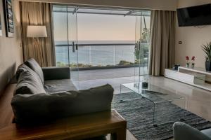 a living room with a couch and a glass table at La Mariposa Apartments in Manuel Antonio