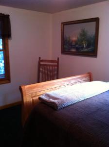埃爾金斯的住宿－Whispering Meadow，卧室配有一张床,墙上挂着一幅画