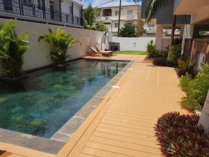 a swimming pool in the side of a building at Sugar Reef Apartment in Flic-en-Flac