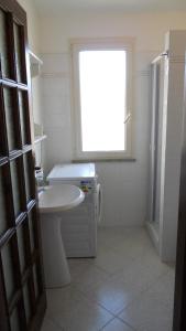 a bathroom with a sink and a toilet and a window at Casa Vacanze La Bandera 2 in Santa Teresa Gallura