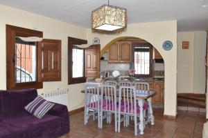 a living room with a table and a purple couch at Apartamentos Vista Veleta in Capileira