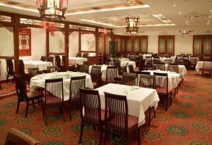 un comedor con mesas y sillas blancas en un restaurante en Red Lion Inn and Suites Victoria en Victoria