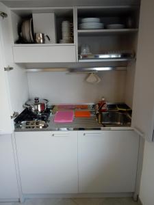 a small kitchen with white cabinets and a stove at Salvia e Timo Rooms in Borso del Grappa