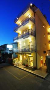 a apartment building with a lit up facade at night at Residence Helene in Tortoreto Lido