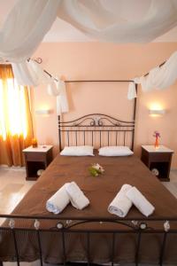 a bedroom with a large bed with two towels at Anna Studios in Agios Prokopios