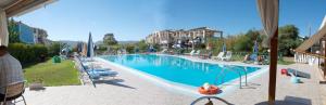 a large swimming pool with chairs and a building at Plubis Studios in Kalamaki