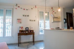 a kitchen with a refrigerator, stove, sink and a window at Jardin de la Alameda Hostal Boutique in Seville