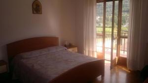 sypialnia z łóżkiem i dużym oknem w obiekcie Champdepraz Casa Vacanze w mieście Champdepraz