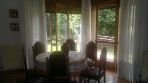 een eetkamer met een tafel en stoelen en een raam bij Champdepraz Casa Vacanze in Champdepraz