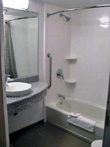 a bathroom with a sink and a tub and a mirror at Motel 6-Marble Falls, TX in Marble Falls