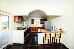 a kitchen with a counter with chairs and a refrigerator at Mirador del Castillo in Tenexcalco