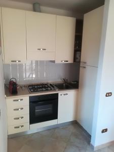 a kitchen with white cabinets and a stove top oven at Casa Tafi in Castelfiorentino