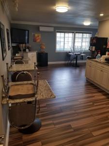 a large living room with wooden flooring and a kitchen at Best Western Orange Plaza in Orange