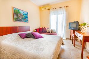 a bedroom with a bed and a tv and a couch at Vongola in Utjeha