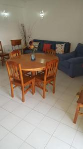 einen Holztisch und Stühle im Wohnzimmer in der Unterkunft casa dos avós in Albufeira