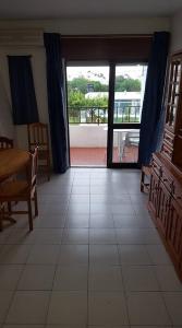 ein Wohnzimmer mit einem Tisch und einer großen Glastür in der Unterkunft casa dos avós in Albufeira