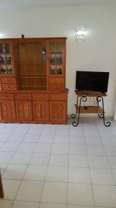 ein Wohnzimmer mit einem Flachbild-TV und einem Tisch in der Unterkunft casa dos avós in Albufeira