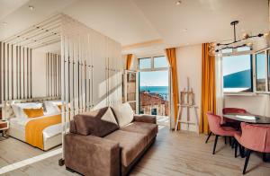 a bedroom with a bed and a couch and a table at Apartments Master 5 in Herceg-Novi