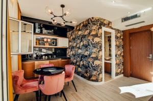 a kitchen with a table and some pink chairs at Apartments Master 5 in Herceg-Novi