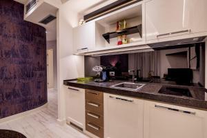 a kitchen with white cabinets and a sink at Apartments Master 5 in Herceg-Novi