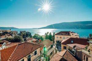 a view of a city with the sun in the sky at Apartments Master 5 in Herceg-Novi