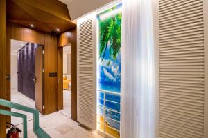 a hallway with a wall mural of a palm tree at Apartments Master 5 in Herceg-Novi