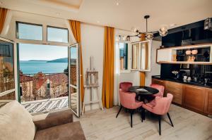 a living room with a table and chairs and a balcony at Apartments Master 5 in Herceg-Novi