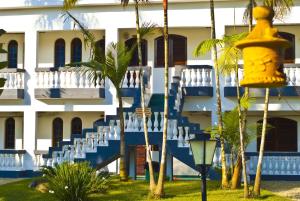 a building with blue and white stairs and palm trees at Pousada Bem Viver in Ubatuba