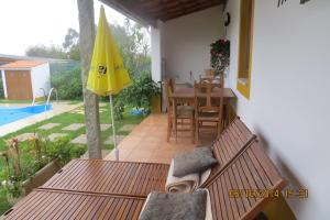 patio con tavolo e ombrellone giallo di Casa da Avó, campo praia a 2 kms do mar a Espinho