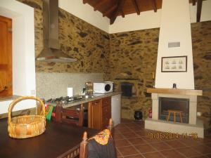 una cucina con tavolo, piano cottura e camino di Casa da Avó, campo praia a 2 kms do mar a Espinho