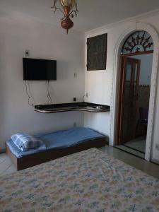 a bedroom with a bed and a tv and a mirror at Casa da Josi - Pajuçara in Maceió