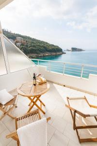 a balcony with a table and chairs and the ocean at Pansion Vongola in Utjeha