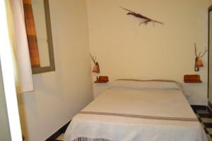 Habitación blanca pequeña con cama. en Hostería Rural Monte Bérico en Los Hornillos