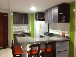 cocina con paredes de color negro y verde y nevera blanca en Apartamentos Cartagena, en Cartagena de Indias