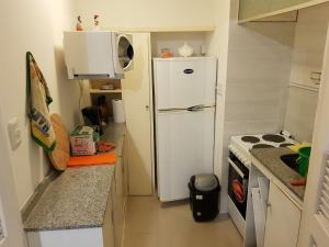a small kitchen with a white refrigerator and a microwave at APTO 913 - Piso 9 SANTOS DUMONT Excepcional vista al mar y a la ciudad in Punta del Este