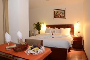 a bedroom with a bed with a basket of fruit on a table at Golden Inca Hotel in Cusco