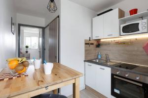a kitchen with a wooden table with fruit on it at Cosy Solidor Beach View in Saint Malo